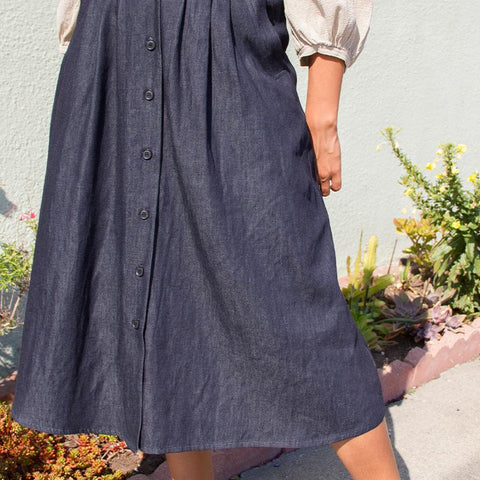 Close up of model in long dark blue denim button up maxi skirt 